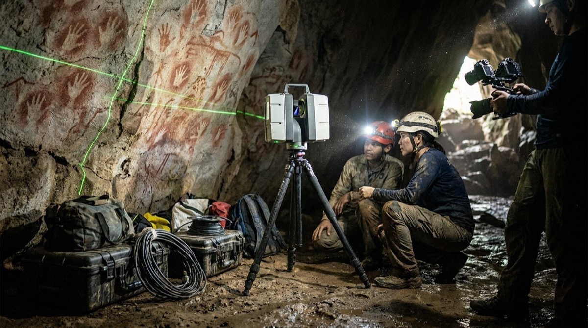 A laser scanner recording hand stencil panels inside the cave, crew working alongside it